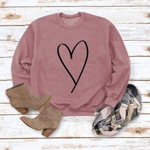 Flat lay of pink sweatshirt with minimalist heart print, scarf, and brown boots