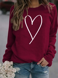 Detail of burgundy long sleeve sweatshirt with white heart print and round neck collar