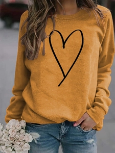 Close-up of ginger orange crewneck sweatshirt with minimalist black line heart print