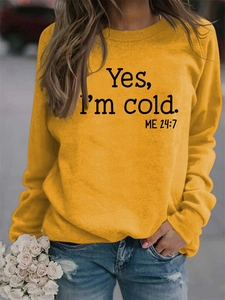 Outdoor shot of ginger yellow crewneck sweatshirt with 'Yes, I'm cold' print and denim jeans