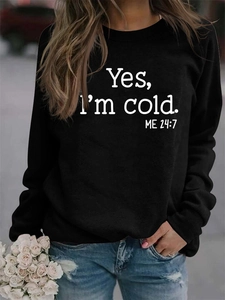 Detail of a black crewneck sweatshirt with a white Yes I'm Cold slogan print