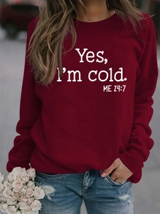 Detail of burgundy sweatshirt with Yes I am Cold print on a model in outdoor street