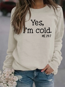 Detail of cream sweatshirt with black 'Yes, I'm cold. ME 24:7' print and crew neck