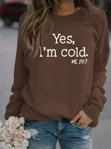 Detail of loose fit brown sweatshirt featuring Yes I'm Cold print and ribbed crew neck