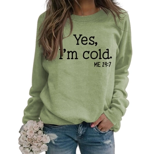 Detail of light green sweatshirt with black Yes I'm Cold 24/7 print and round neckline