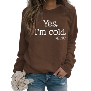 Detail of soft brown knit sweater featuring Yes I'm Cold 24:7 white printed typography
