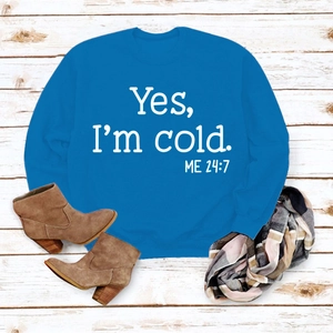 Flat lay of royal blue sweatshirt with white text print and winter accessories