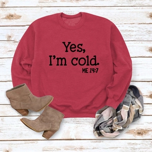Flat lay of red sweatshirt with 'Yes I'm cold' print, boots and plaid scarf outfit