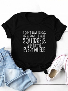 T-shirt nera in cotone con stampa di slogan bianco su una superficie di legno chiaro
