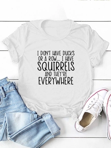 T-shirt bianca in cotone con citazione ironica e jeans blu su sfondo in legno bianco