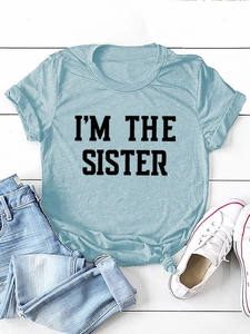 Détail du t-shirt bleu clair avec motif I'M THE SISTER et nœud élégant à l'ourlet