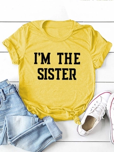 Détail du t-shirt jaune en coton avec imprimé I'M THE SISTER et nœud élégant à l'ourlet