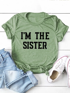 Détail du t-shirt vert en coton noué à l'ourlet avec imprimé I'M THE SISTER