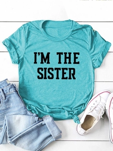 T-shirt bleu ciel à plat avec imprimé I'M THE SISTER sur fond de bois blanc