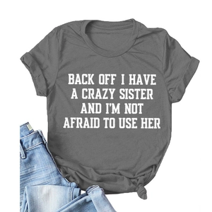 Flat lay detail of dark grey crew neck T-shirt with bold slogan text and blue denim jeans