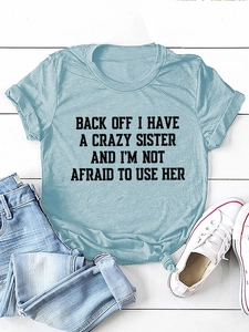 Flat lay of light blue cotton T-shirt with black slogan print and denim pants