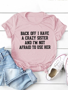 Detail of pink crewneck t-shirt with slogan print and stylish knotted hem on flat lay