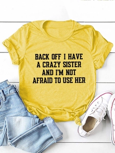 Flat lay of yellow cotton t-shirt with black slogan text and blue denim jeans