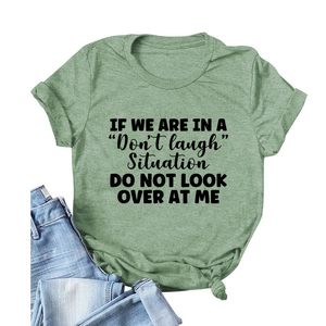Women's sage green cotton T-shirt featuring a black graphic slogan and a stylish knotted hem