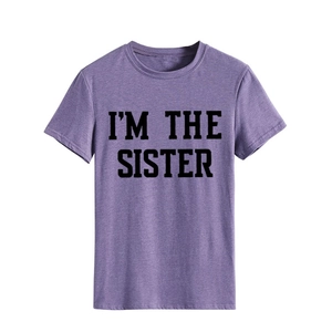Détail de l'imprimé I'M THE SISTER sur un t-shirt violet en coton à col rond