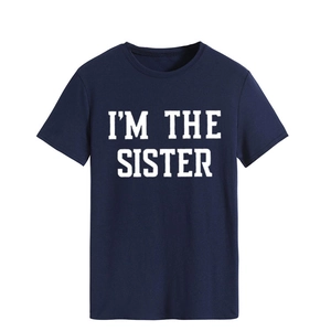 Gros plan sur l'imprimé blanc I'M THE SISTER sur un t-shirt en coton bleu marine
