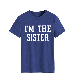 Gros plan sur l'imprimé blanc I'M THE SISTER du t-shirt bleu marine à manches courtes