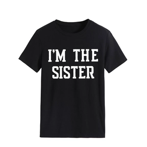 Vue détaillée de l'imprimé blanc I'M THE SISTER sur un t-shirt noir à manches courtes