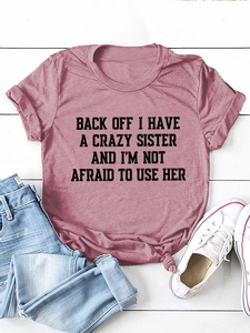 Flat lay of pink letter print T-shirt paired with jeans and canvas shoes on white wood
