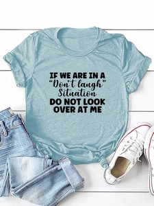 Detail of light blue knotted T-shirt with humorous quote flat lay and white sneakers