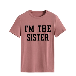 Détail de l'imprimé I'M THE SISTER sur un t-shirt rose poudré en coton à col rond classique