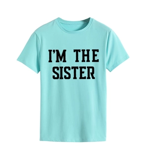 Gros plan sur l'imprimé I'M THE SISTER noir sur un t-shirt à manches courtes vert menthe
