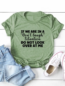 Close-up of green cotton T-shirt with black text print and stylish front knot detail