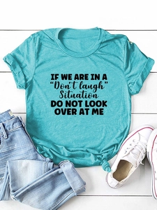 Flat lay of a turquoise t-shirt with print slogan styled with jeans and sneakers
