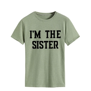 Gros plan du texte I'M THE SISTER imprimé sur un t-shirt en coton vert pastel clair