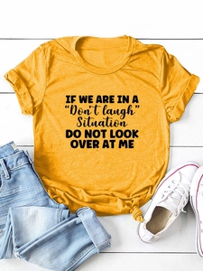 Flat lay of mustard yellow cotton T-shirt with black text slogan and casual denim jeans