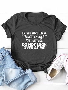 Detail of soft dark grey cotton t-shirt featuring a white humorous slogan flat lay