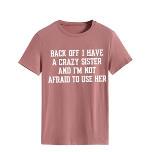 Close-up of crew neck t-shirt with slogan print on soft dusty pink cotton fabric
