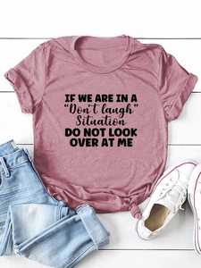 Flat lay of pink cotton T-shirt with black letter print and casual styling accessories