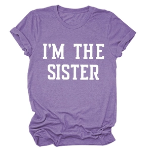 Détail à plat d'un t-shirt violet avec imprimé blanc I'M THE SISTER sur tissu doux