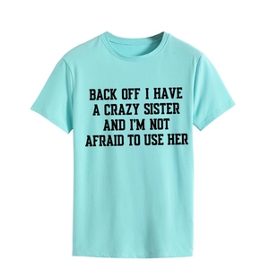 Close-up of Back Off I Have A Crazy Sister bold text print on light blue cotton T-shirt