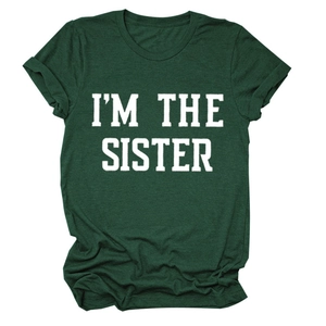 Détail du slogan blanc I'M THE SISTER imprimé sur un t-shirt vert foncé à col rond
