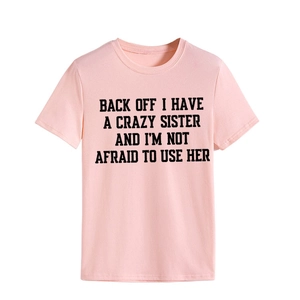 Detail of pink cotton T-shirt featuring a black retro slogan print and ribbed crew neck