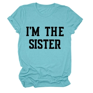 Détail de l'imprimé noir I'M THE SISTER sur un t-shirt en coton bleu ciel doux
