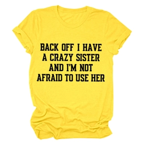 Detail of yellow round neck T-shirt with black Back Off I Have A Crazy Sister printed text