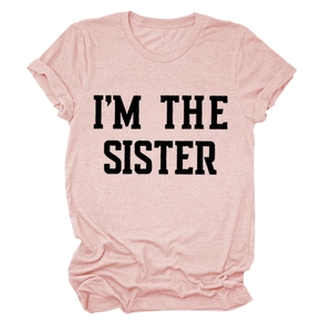 Détail d'un t-shirt en coton rose avec inscription noire I'M THE SISTER imprimée
