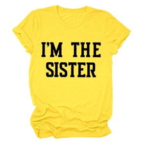 Détail d'un t-shirt jaune à col rond en coton avec l'imprimé noir I'M THE SISTER en gras