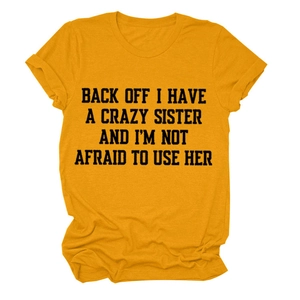 Detail of mustard yellow cotton T-shirt featuring bold black slogan graphic print