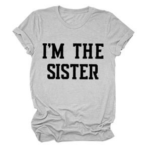 Détail macro de l'imprimé 'I'M THE SISTER' sur un t-shirt en coton gris chiné