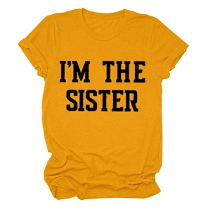 Détail du t-shirt jaune gingembre avec l'imprimé texte noir I'M THE SISTER