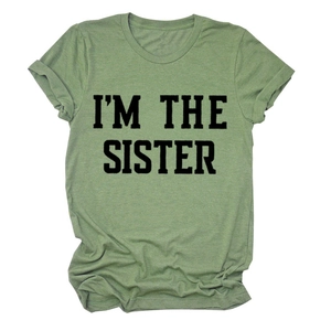 Détail de l'imprimé I'M THE SISTER sur un t-shirt vert gazon à col rond en coton